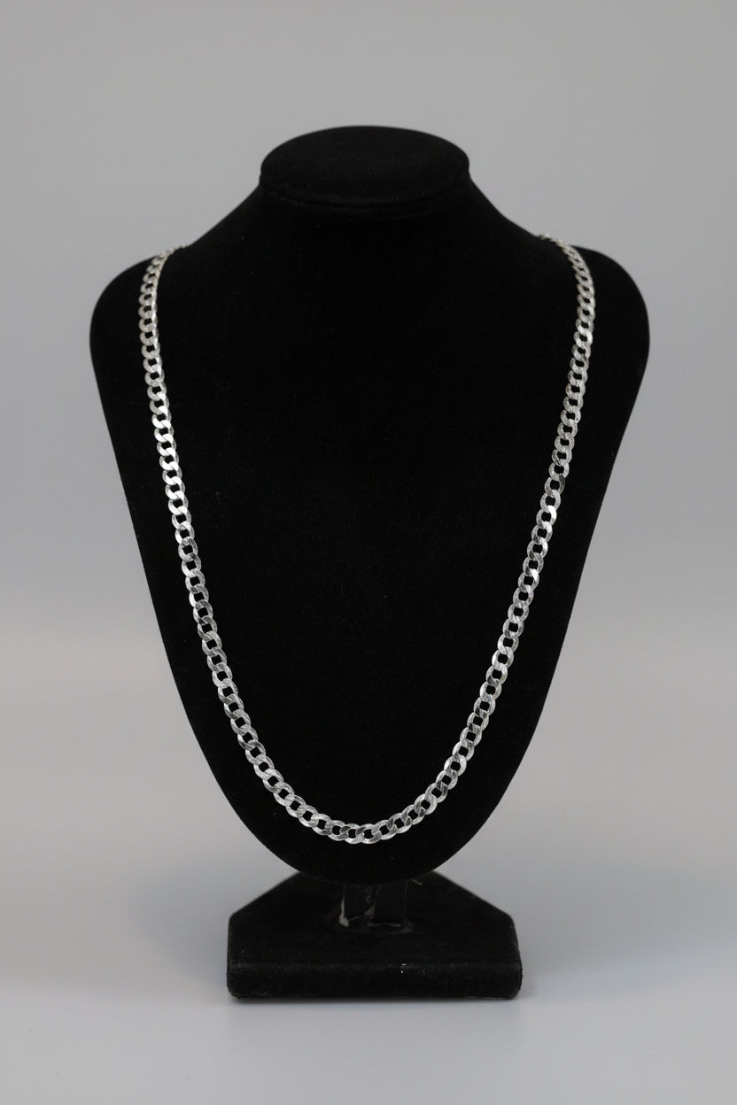 Silver chain necklace on a black mannequin bust against a dark background