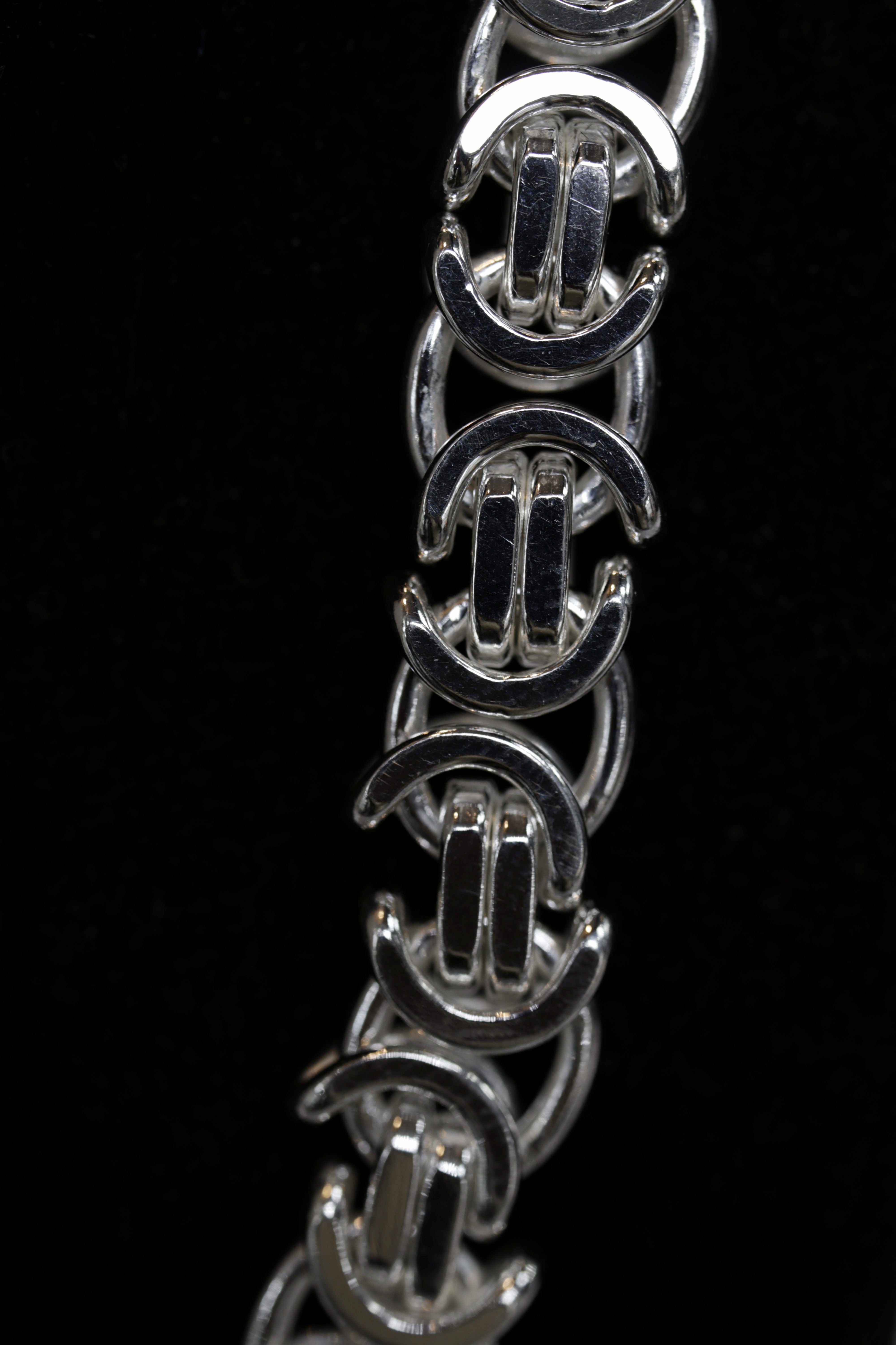 Close-up of a silver bracelet on a black background