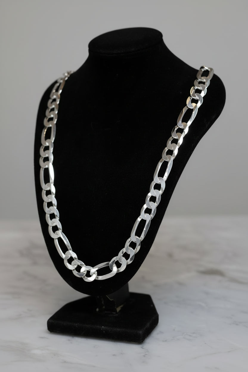 Silver chain necklace on a black mannequin bust against a neutral background