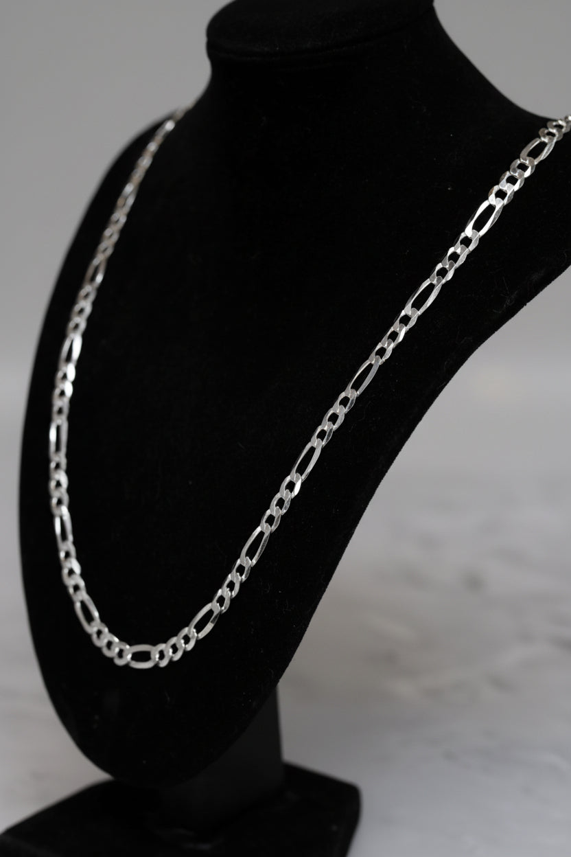 Silver chain necklace on a black mannequin bust.