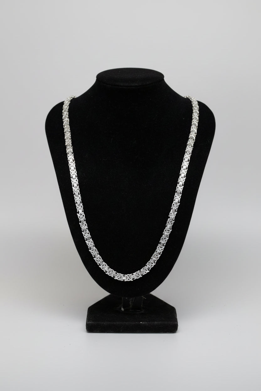 sterling Silver chain necklace on a black stand with a blurred background