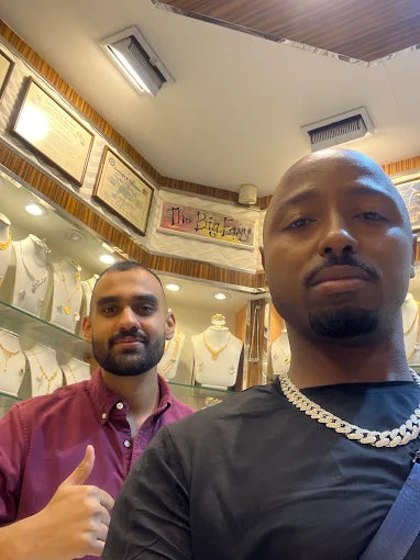 Two men standing in a jewelry store with display cases in the background