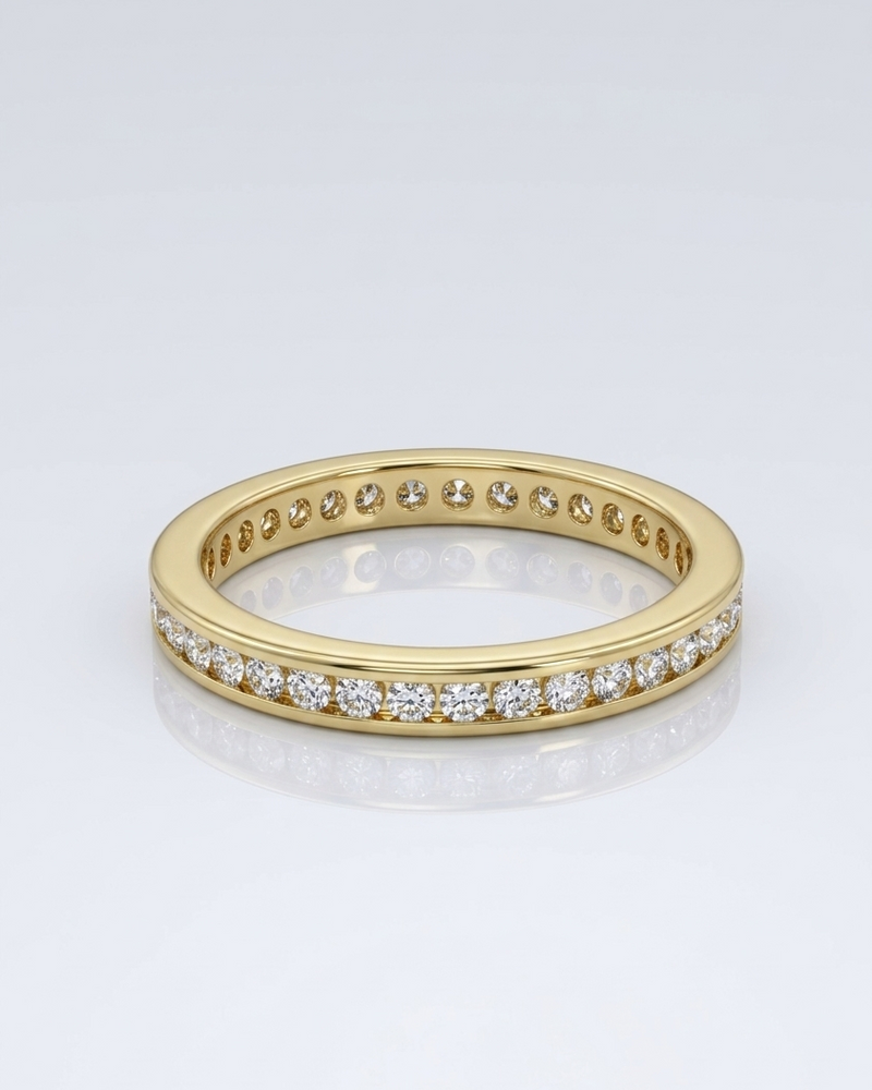 Gold ring with embedded diamonds on a light gray background